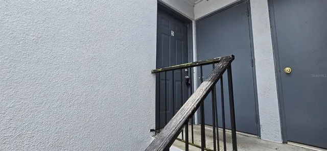 a view of staircase with wooden floor and white walls