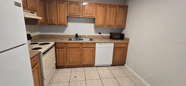 a kitchen with a sink a stove and cabinets
