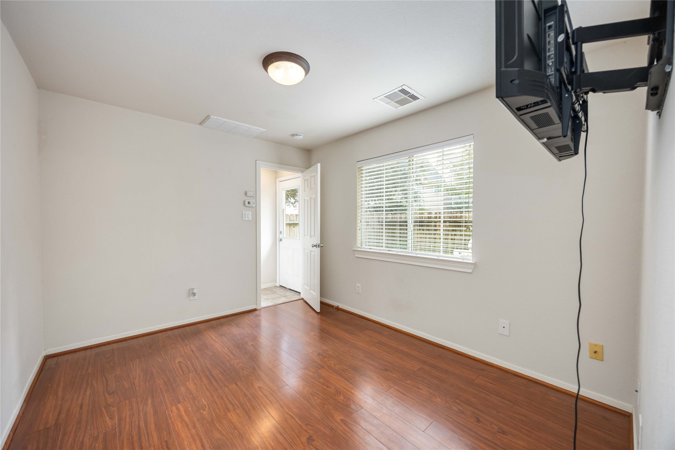 3008 Clearview Circle Houston, TX 77025 - Photo 19 of 33 an empty room with wooden floor and windows