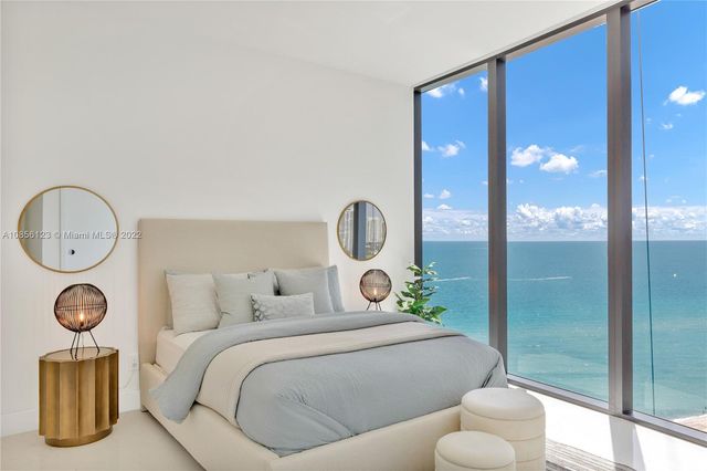 a living room with furniture a flat screen tv and a floor to ceiling window