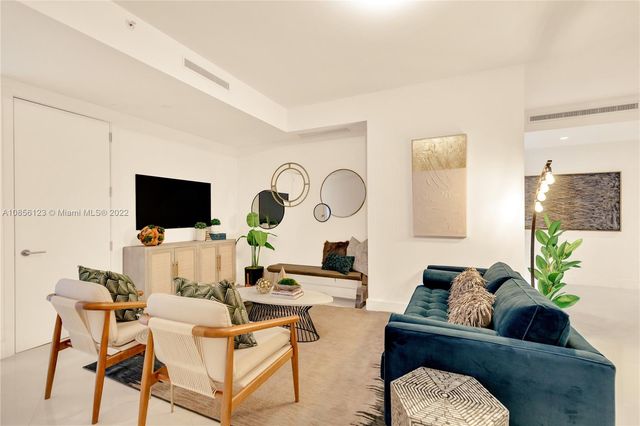 a living room with fireplace furniture and a potted plant
