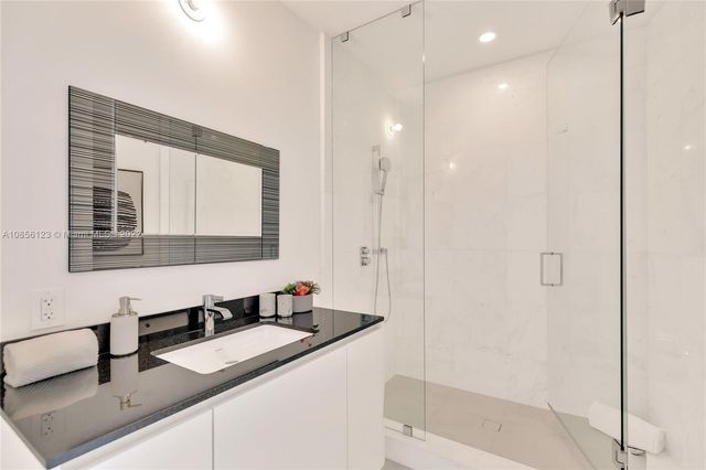 a large kitchen with kitchen island a large counter top stainless steel appliances and cabinets