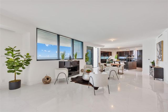 a kitchen with stainless steel appliances a dining table chairs and wooden floor