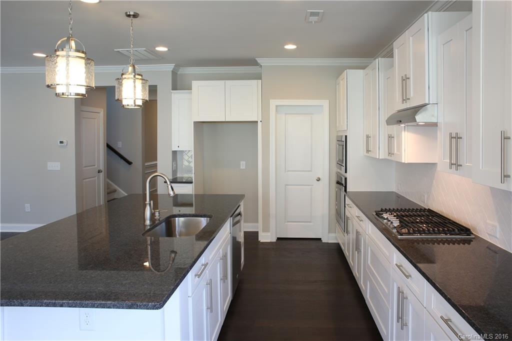 144 Helton Lane, Unit 35 Fort Mill, SC 29708 - Photo 4 of 18 a kitchen with kitchen island granite countertop a sink stainless steel appliances and cabinets