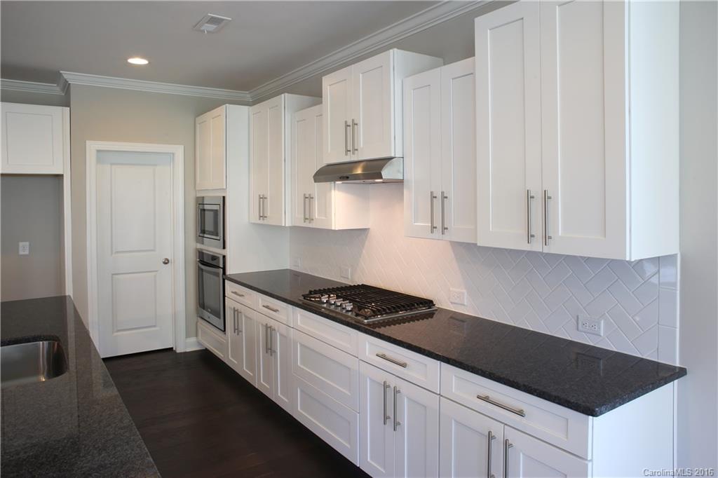 144 Helton Lane, Unit 35 Fort Mill, SC 29708 - Photo 5 of 18 a kitchen with granite countertop white cabinets and black appliances