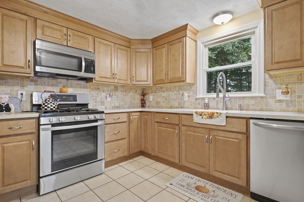 14 Porter Street Billerica, MA 01821 - Photo 13 of 33 a kitchen with stainless steel appliances granite countertop a stove a sink and a microwave