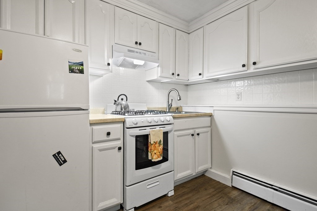 14 Porter Street Billerica, MA 01821 - Photo 27 of 33 a kitchen with white cabinets and white appliances