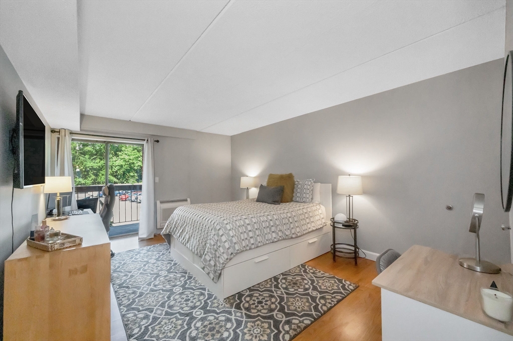 159 Main Street, Unit 15B Stoneham, MA 02176 - Photo 11 of 25 a bedroom with a bed and flat screen tv