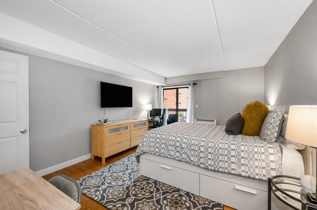 159 Main Street, Unit 15B Stoneham, MA 02176 - Photo 12 of 25 a bedroom with a bed and a flat screen tv