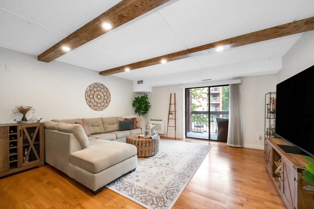 159 Main Street, Unit 15B Stoneham, MA 02176 - Photo 6 of 25 a living room with furniture and a flat screen tv