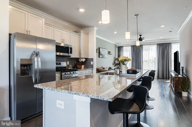 a kitchen with stainless steel appliances granite countertop a sink a stove and a refrigerator