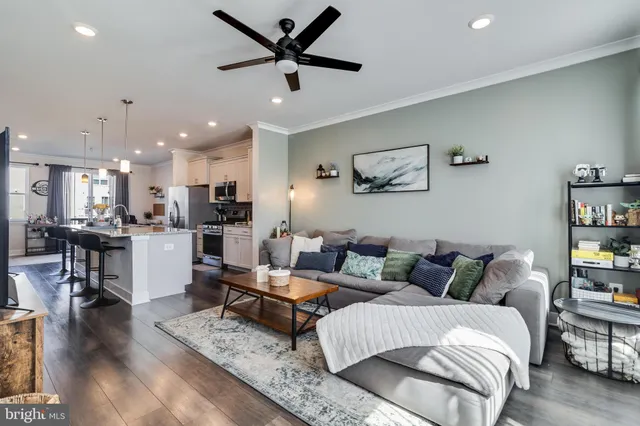 a living room with furniture and a view of kitchen