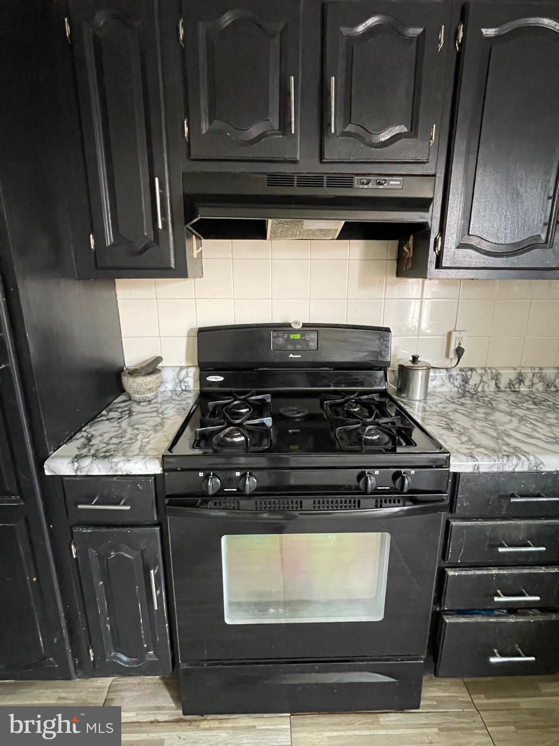 735 Grant Road Folcroft, PA 19032 - Photo 24 of 39 Sleek black kitchen with marble accents.