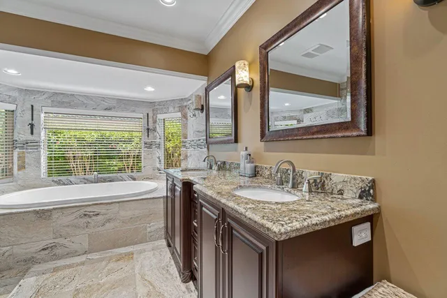 a bathroom with a granite countertop sink and a large mirror