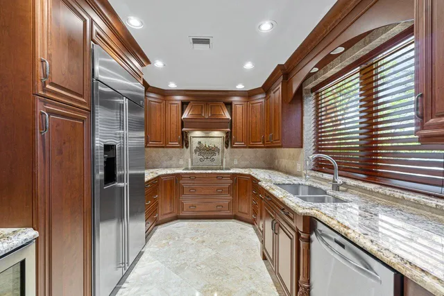 a kitchen with granite countertop a sink and stainless steel appliances