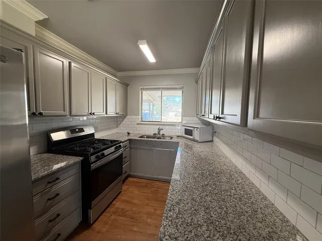 a kitchen with granite countertop stainless steel appliances and wooden cabinets