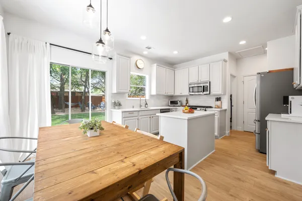 a kitchen with white cabinets and white appliances