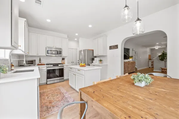 a kitchen with a table chairs refrigerator and microwave