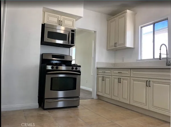 a kitchen with stainless steel appliances a stove microwave and sink