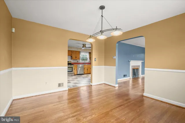 a view of a big room with wooden floor and windows