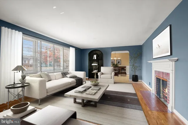 a living room with furniture fireplace and a large window