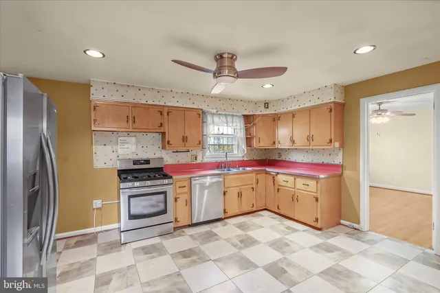 a kitchen with stainless steel appliances a stove sink and refrigerator