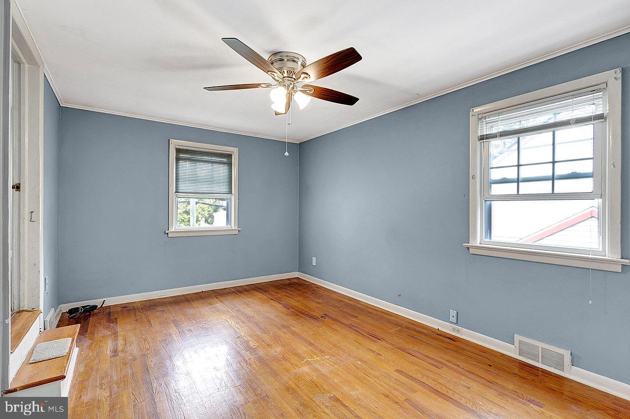 415 Sutherland Road Ewing, NJ 08618 - Photo 16 of 28 an empty room with wooden floor fan and windows