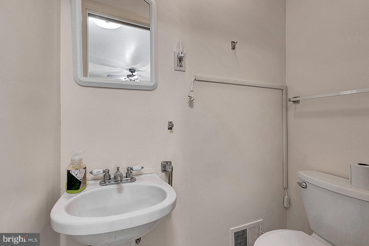 415 Sutherland Road Ewing, NJ 08618 - Photo 10 of 28 a bathroom with a toilet a sink and mirror