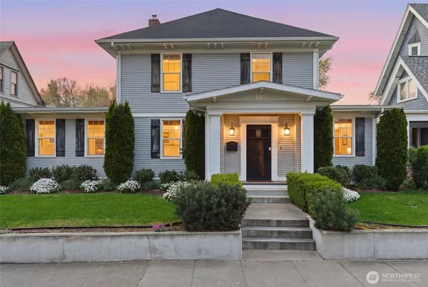 a front view of a house with a yard and potted plants