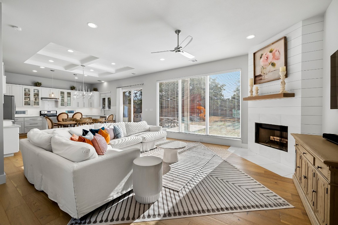 a living room with furniture a fireplace and a floor to ceiling window
