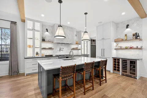 a large kitchen with stainless steel appliances granite countertop a stove a kitchen island a island a table and chairs in it