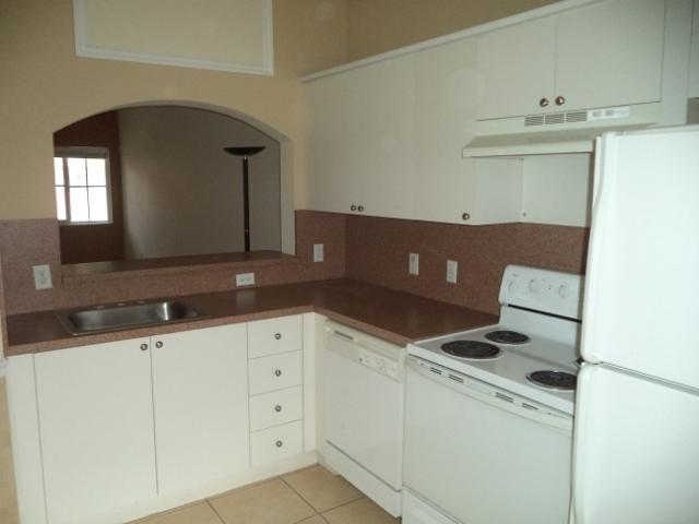 3750 North Jog Road, Unit 203 West Palm Beach, FL 33411 - Photo 4 of 10 a kitchen with granite countertop white cabinets and a stove