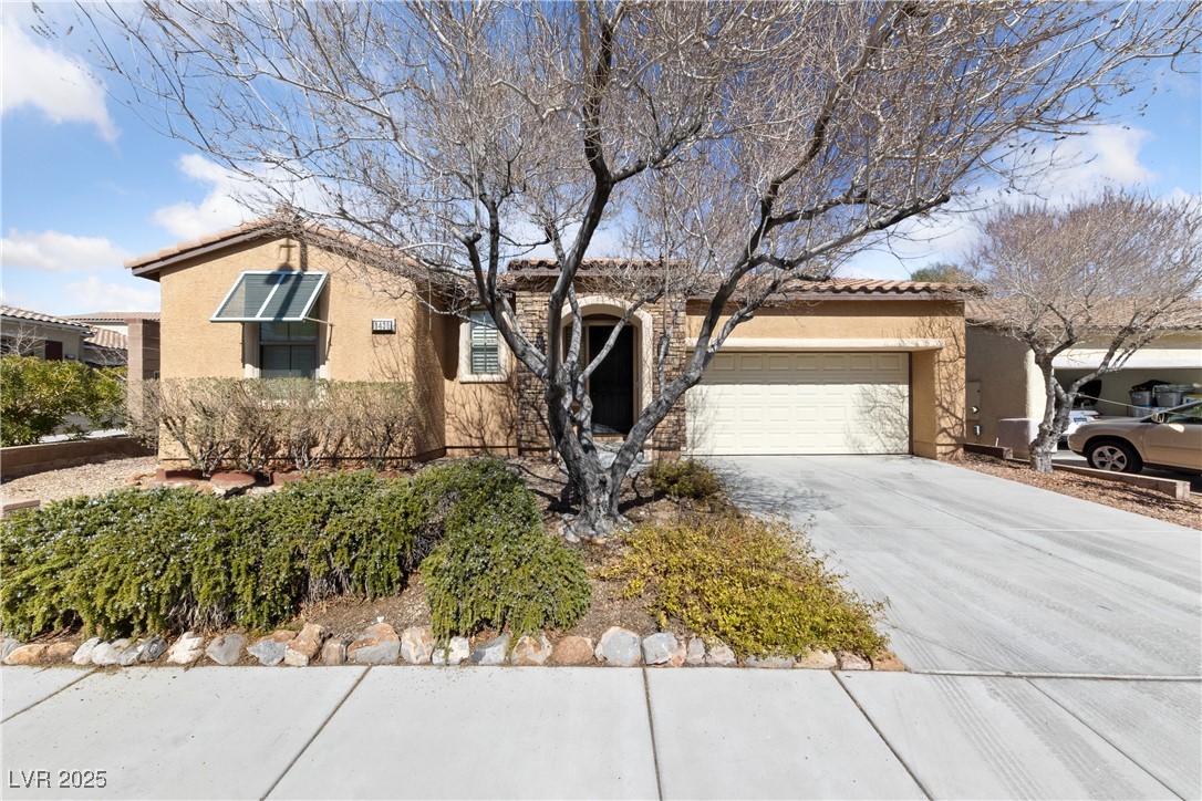 9436 Teton Ridge Avenue Las Vegas, NV 89149 - Photo 1 of 30 Ranch-style house with a garage, a tiled roof, concrete driveway, and stucco siding