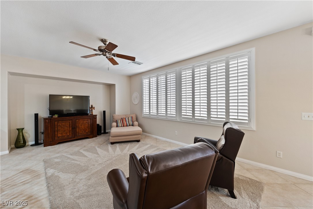9436 Teton Ridge Avenue Las Vegas, NV 89149 - Photo 20 of 30 Living room with a ceiling fan, visible vents, baseboards, and light tile patterned floors