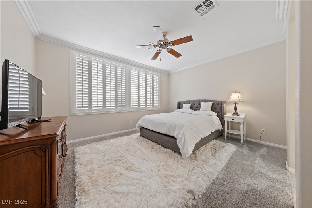 9436 Teton Ridge Avenue Las Vegas, NV 89149 - Photo 7 of 30 Bedroom with carpet floors, crown molding, visible vents, ceiling fan, and baseboards