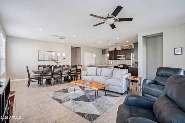 a kitchen with stainless steel appliances granite countertop a table chairs and a refrigerator