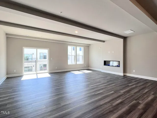 wooden floor fireplace and windows in an empty room