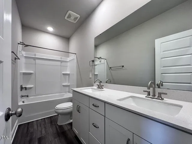 a white bath tub sitting next to a white sink and vanity