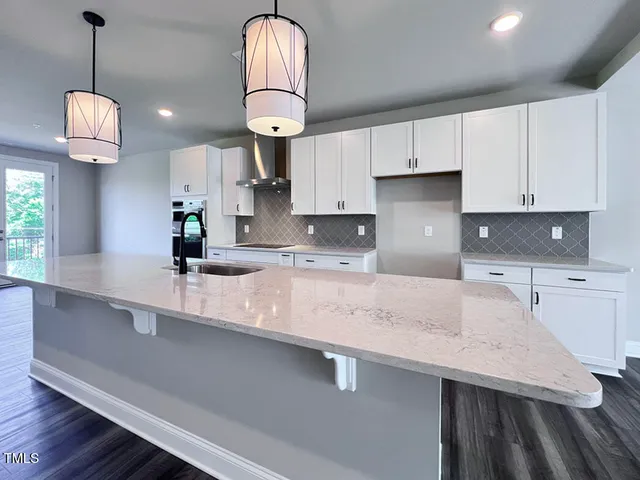 a kitchen with stainless steel appliances a sink a stove a counter space and cabinets
