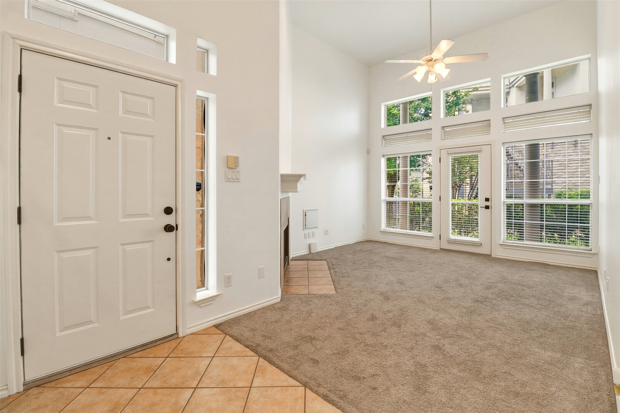 2918 Ranch Road 620, Unit 265 Austin, TX 78734 - Photo 7 of 40 A spacious living area features lofty ceilings, a fireplace, and large windows with abundant natural illumination.