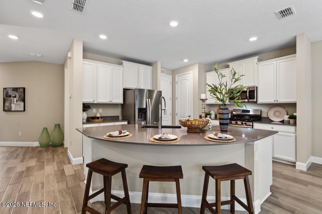 383 Sweet Oak Way St. Augustine, FL 32095 - Photo 13 of 74 a kitchen with a dining table chairs and refrigerator