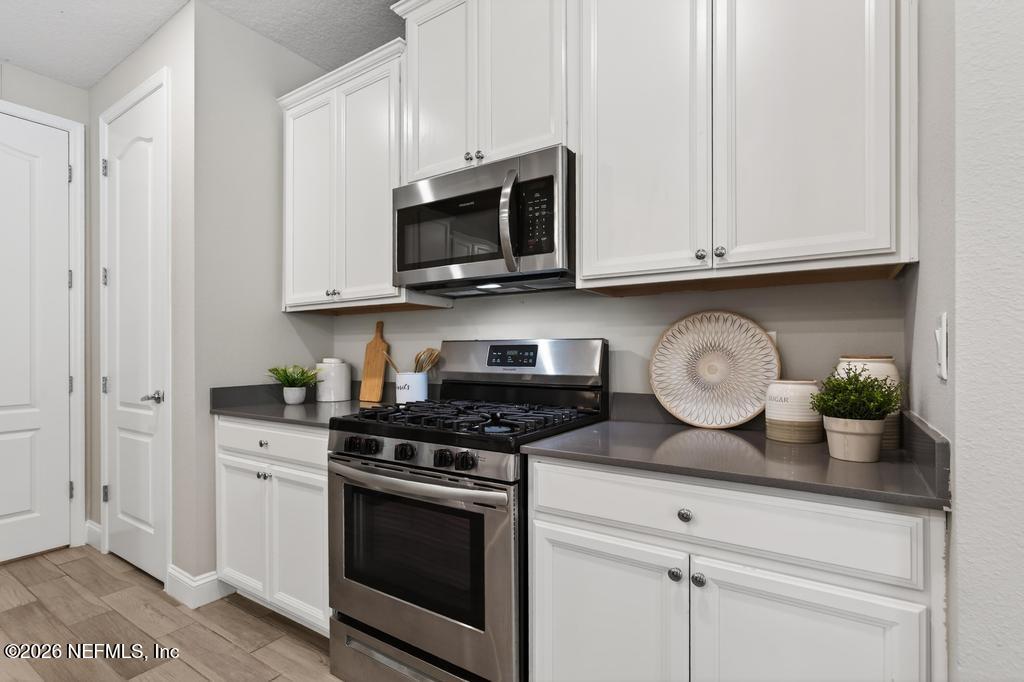 383 Sweet Oak Way St. Augustine, FL 32095 - Photo 17 of 74 a kitchen with stainless steel appliances granite countertop white cabinets a stove a sink and dishwasher