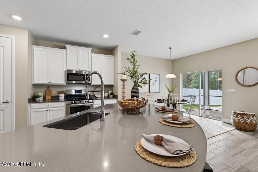 383 Sweet Oak Way St. Augustine, FL 32095 - Photo 19 of 74 a kitchen with sink a stove and cabinets