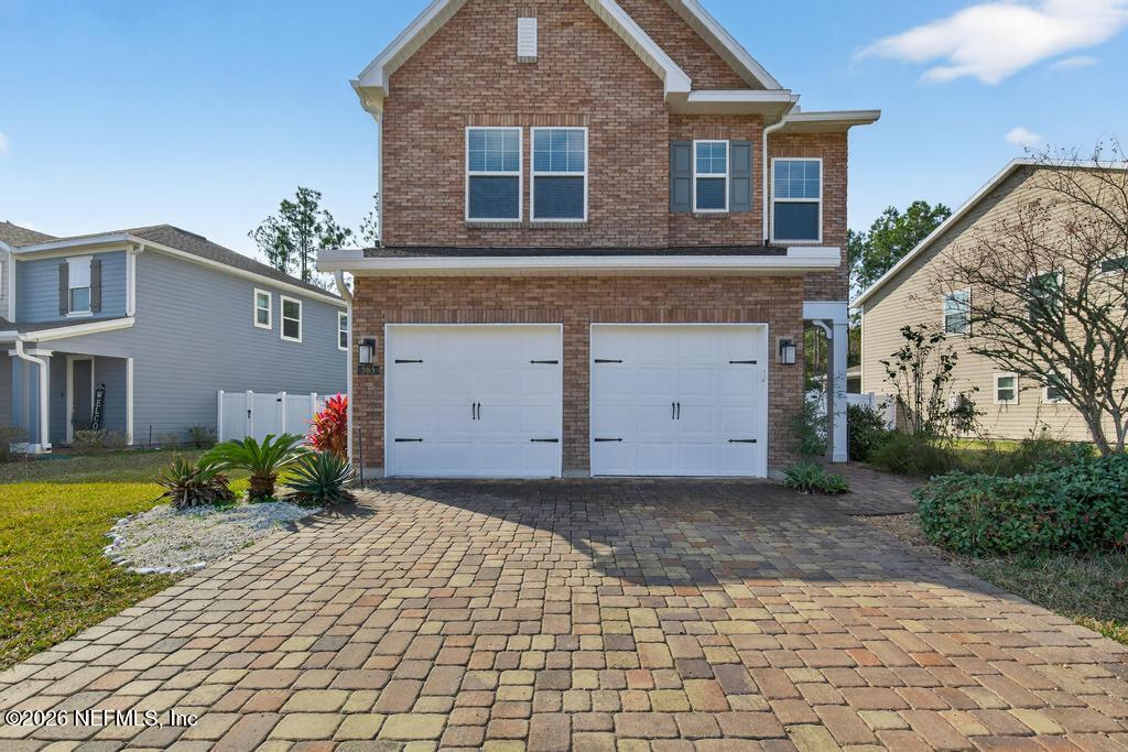 383 Sweet Oak Way St. Augustine, FL 32095 - Photo 2 of 74 a front view of a house with a yard and garage