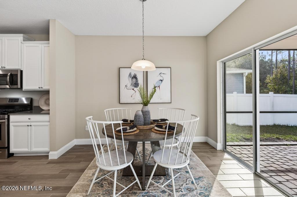 383 Sweet Oak Way St. Augustine, FL 32095 - Photo 25 of 74 a dining room with furniture a chandelier and wooden floor