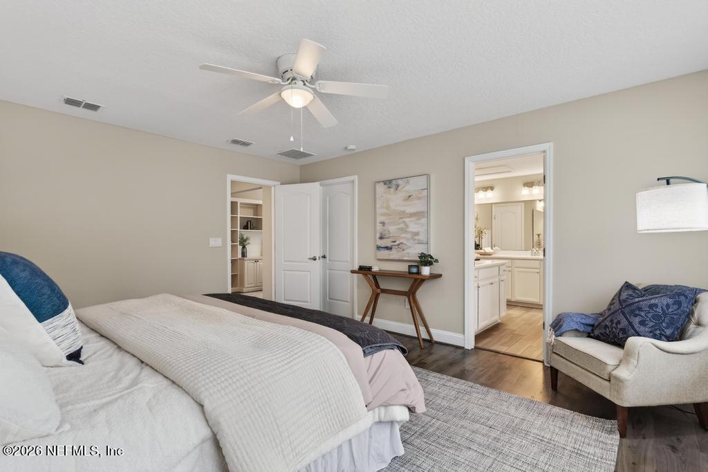383 Sweet Oak Way St. Augustine, FL 32095 - Photo 35 of 74 a spacious bedroom with a bed and a chandelier