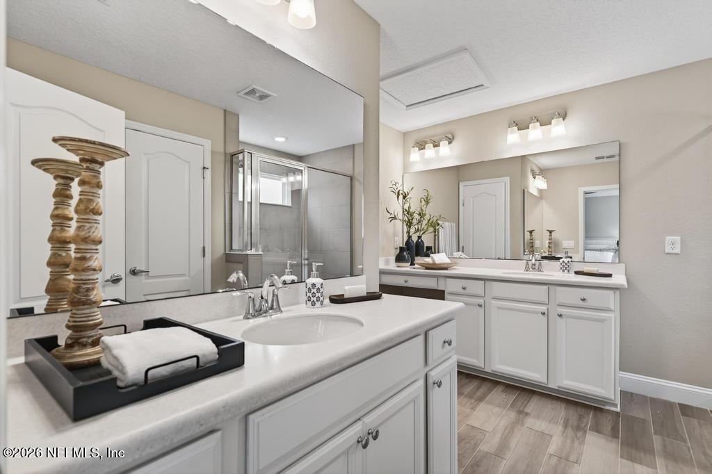 383 Sweet Oak Way St. Augustine, FL 32095 - Photo 37 of 74 a bathroom with a double vanity sink a mirror and a bathtub
