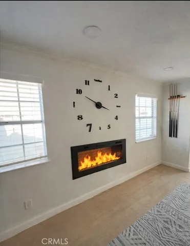 an empty room with windows and fireplace