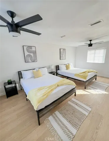 a bedroom with two beds and a desk