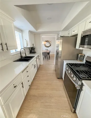 a kitchen with sink stove and refrigerator